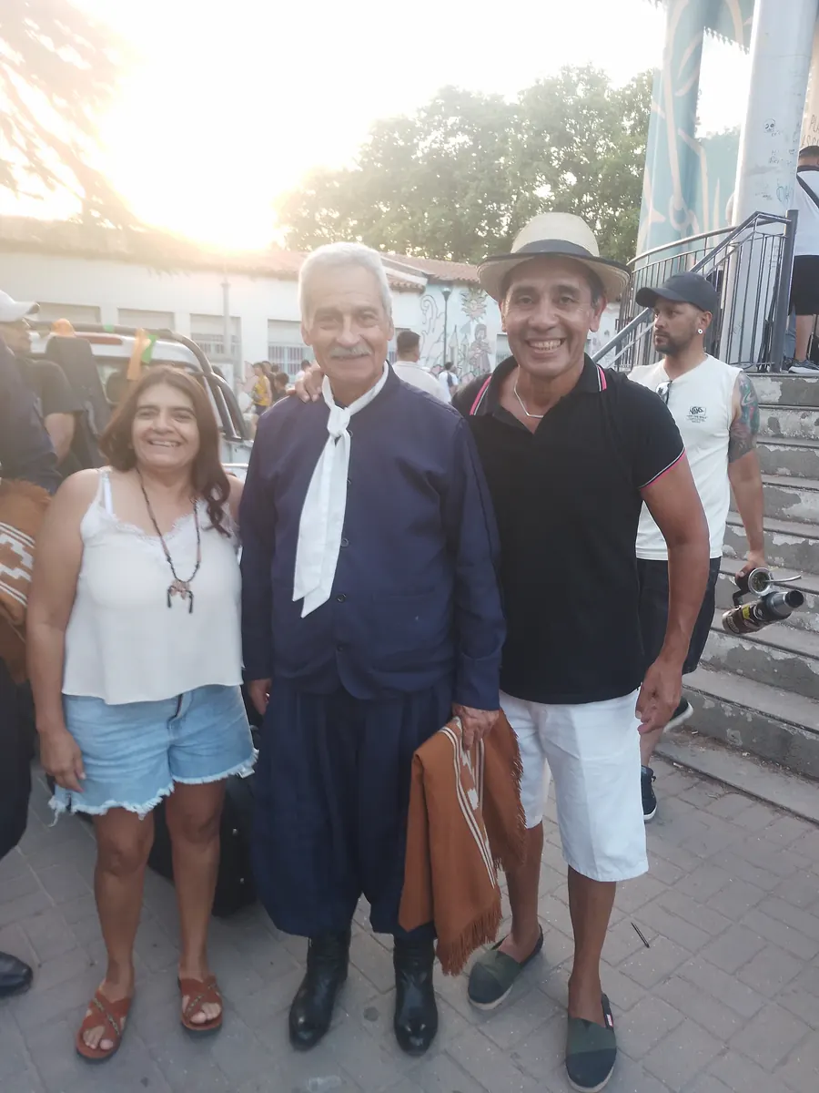 Lina y Eduardo posando junto a un artista invitado en una peña folklórica