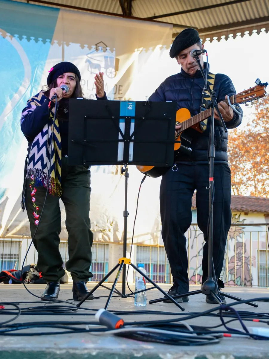 El dúo folklórico cantando en la plaza en una tarde de invierno, con guitarra criolla