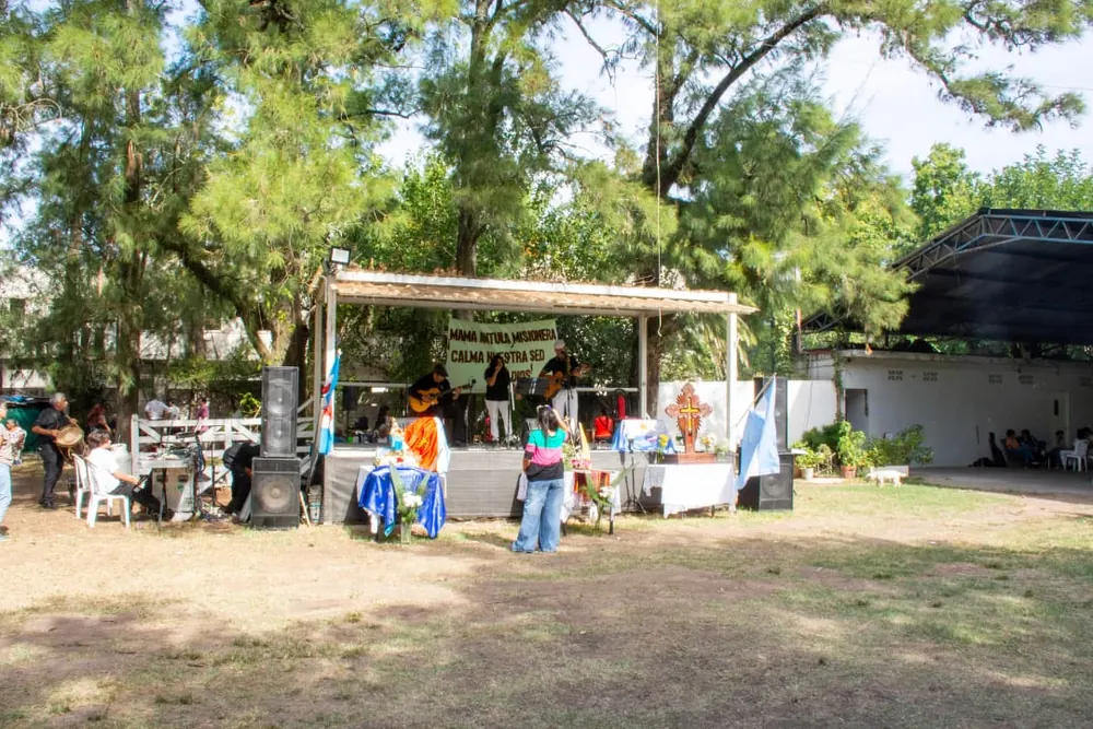 Vista general del festival de folklore al aire libre en un parque con el escenario montado