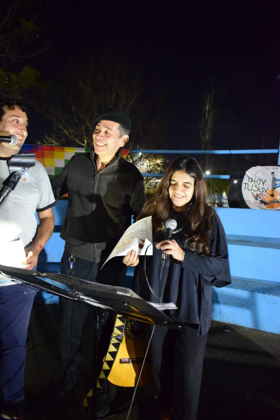 Lina cantando junto a artistas invitados en una peña folklórica nocturna